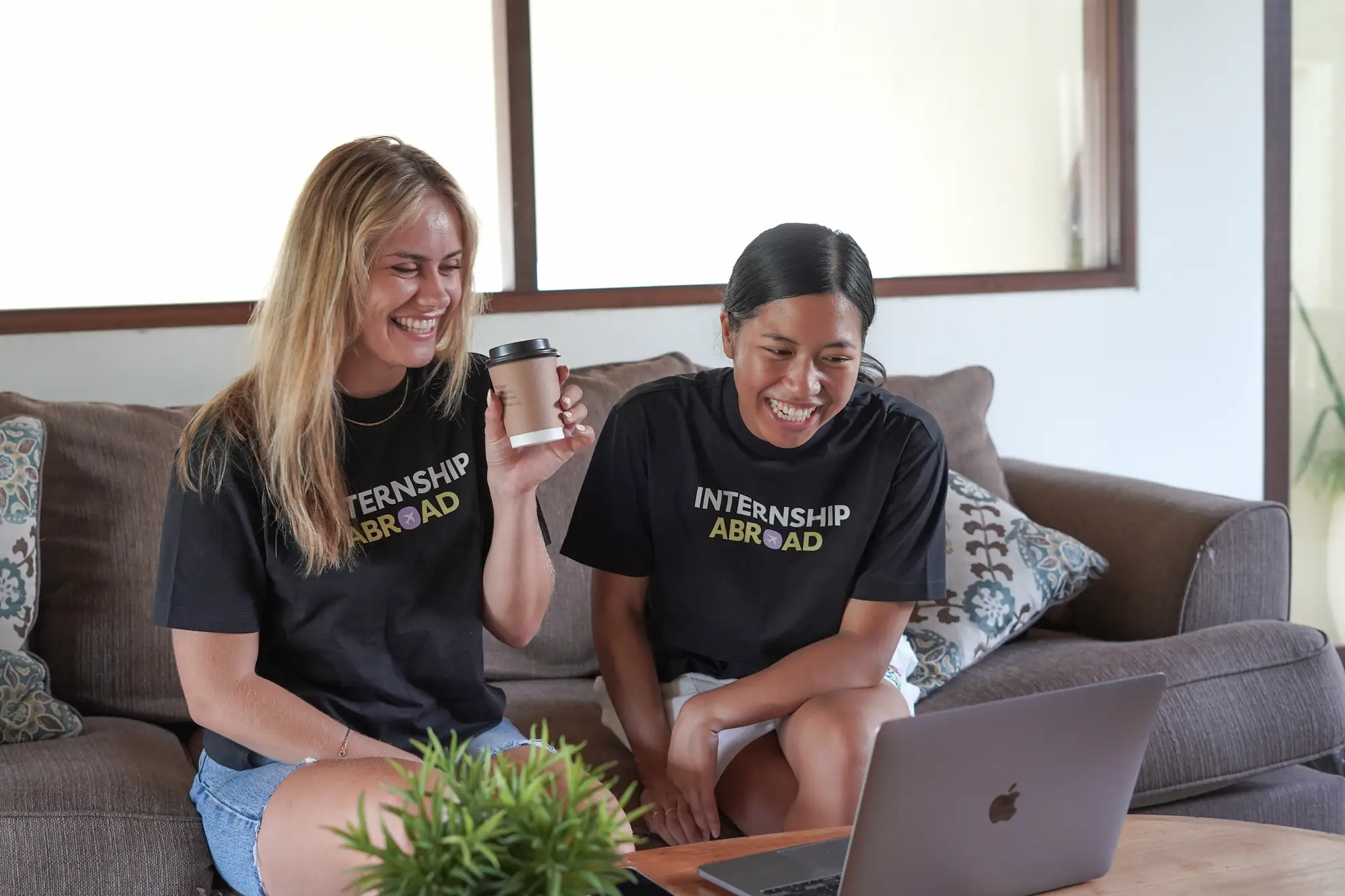 Stážisté Stáž v Zahraničí pracující společně na notebooku ve sdíleném bydlení